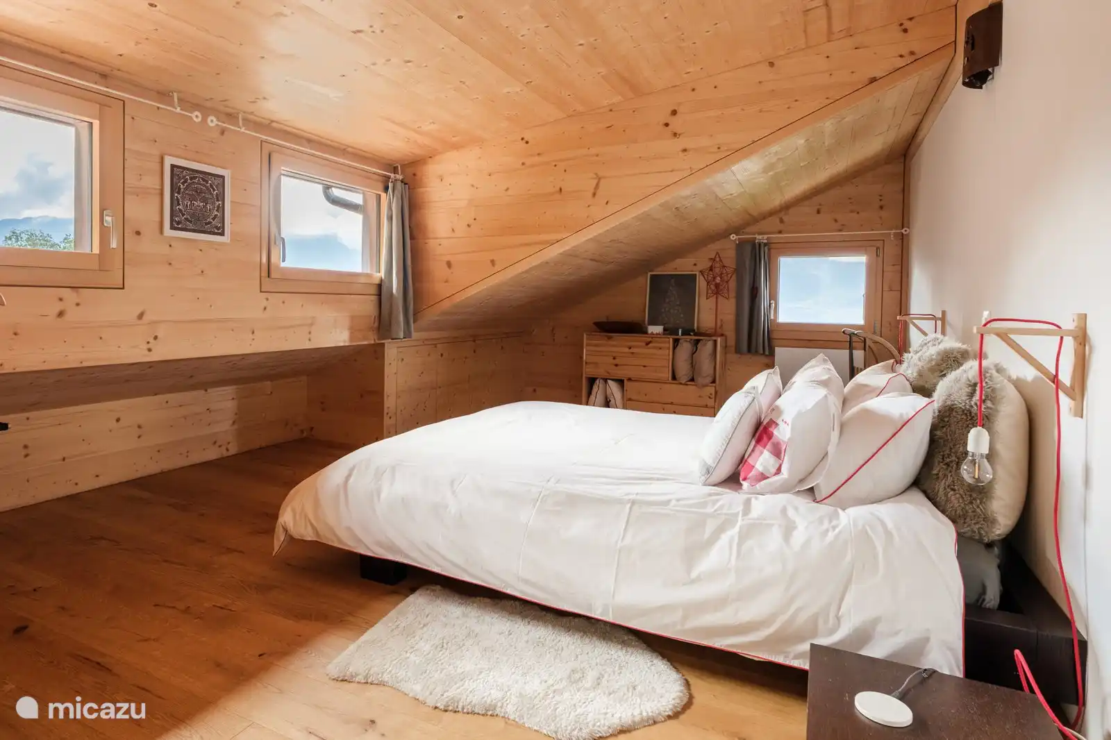 Slaapkamer met tweepersoonsbed onder houten balken