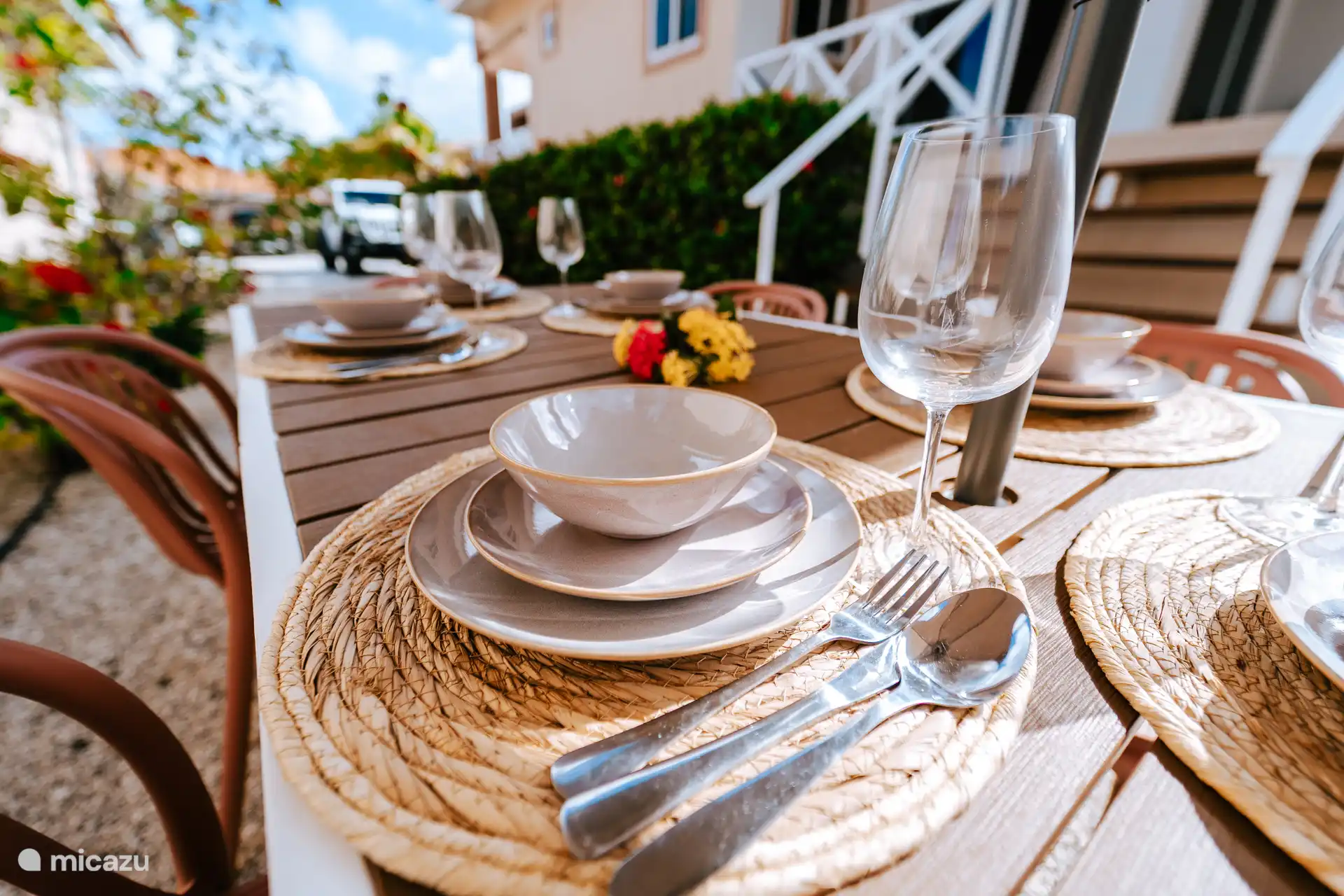 Eettafel met parasol naast de bungalow