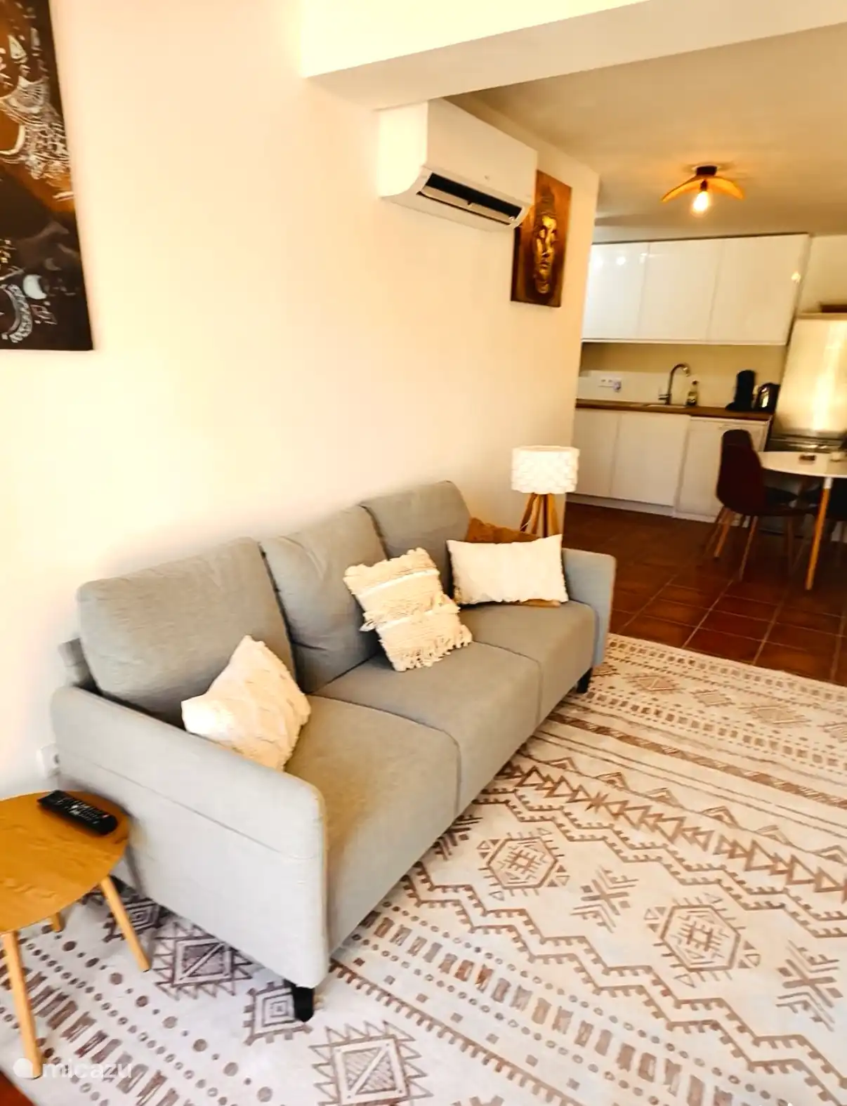 Living room with fully equipped open kitchen, air conditioning and a dining table