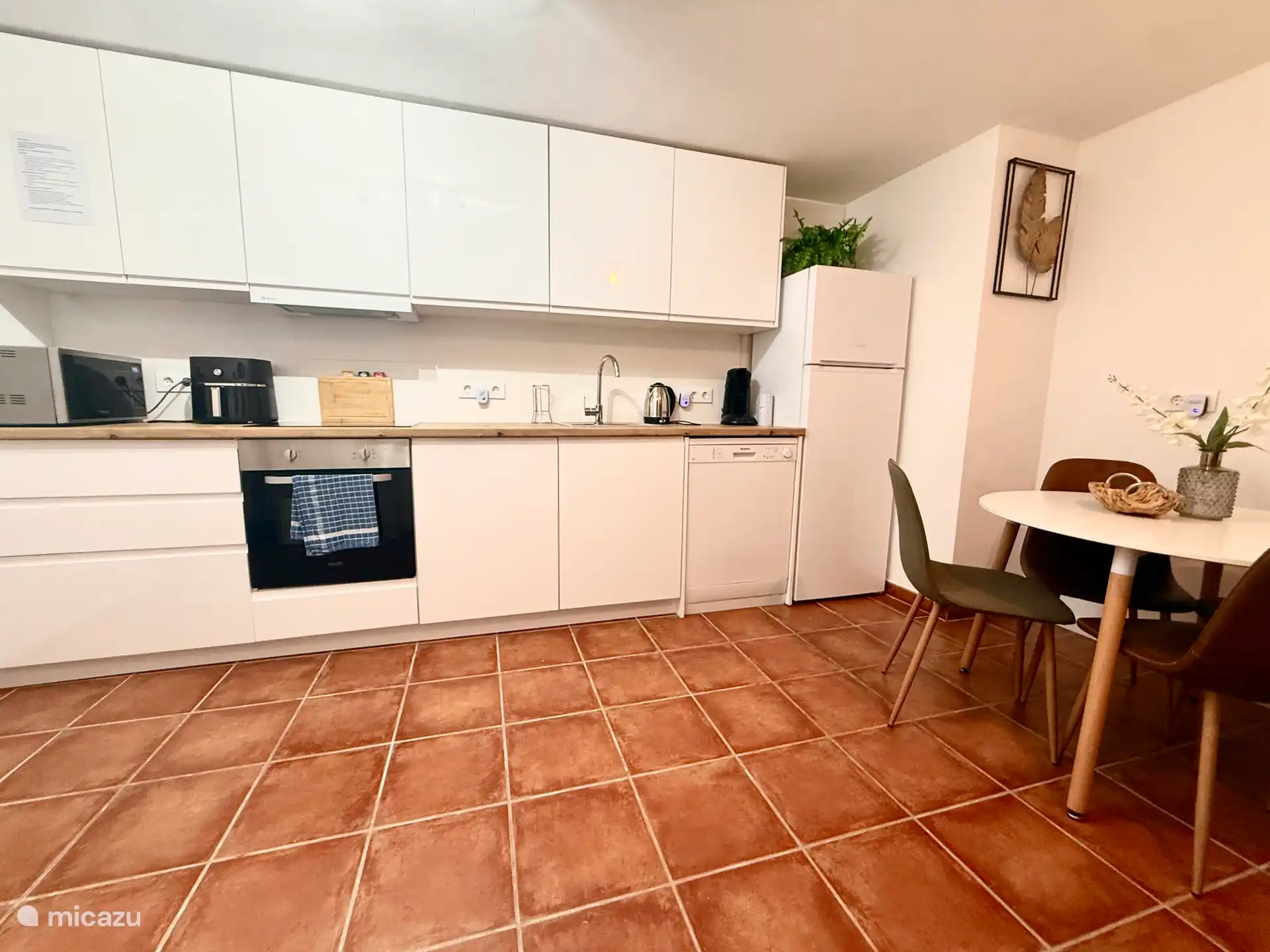 Bulging new equipped kitchen with dishwasher and air fryer.