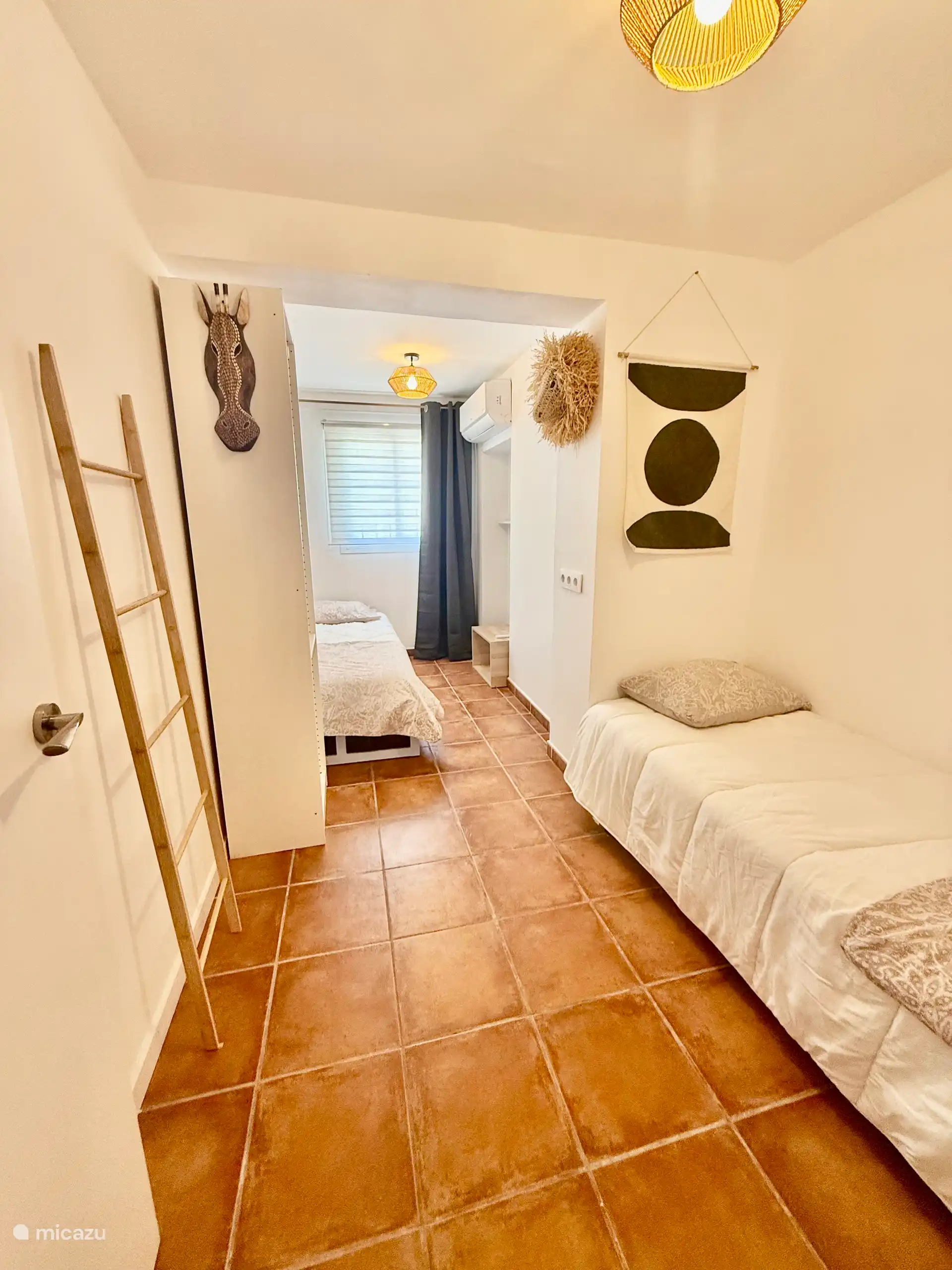 Spacious bedroom with 2 x single beds with air conditioning for heating or cooling.