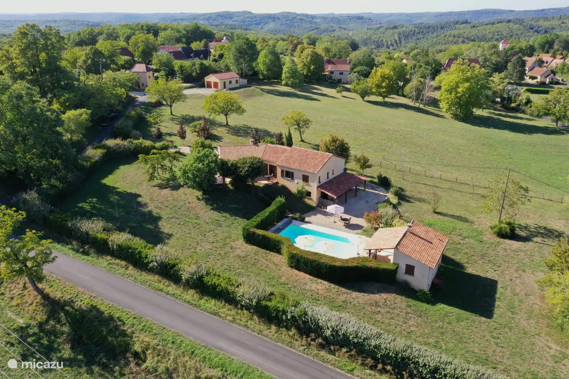 Overview photo of the house and the fenced garden with the swimming pool 