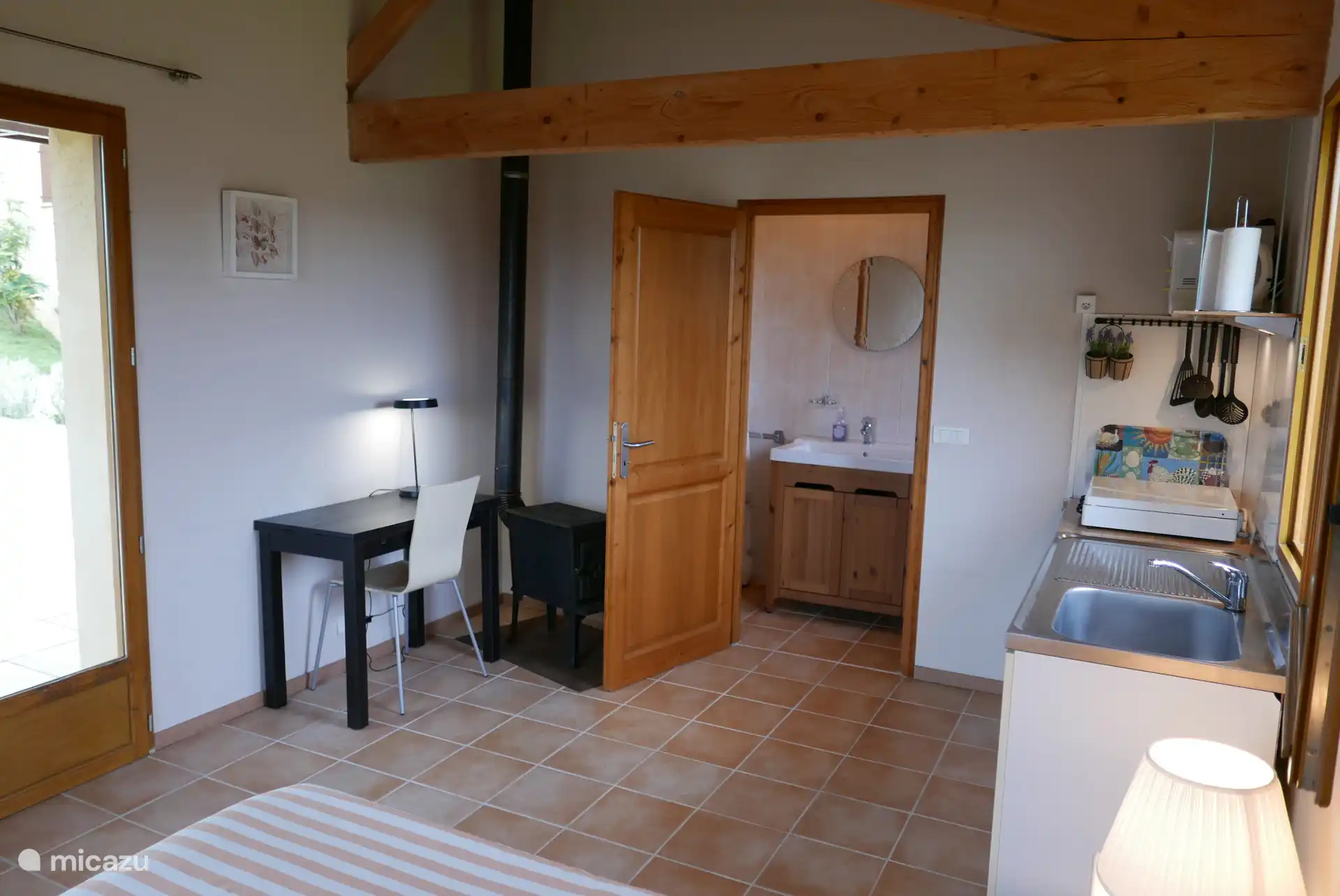 Guest house by the pool for 2 people. Small bathroom with shower, dressing table and toilet. Double bed (140×200) with pillows and blanket. Equipped with wardrobe, table, chair and fridge.