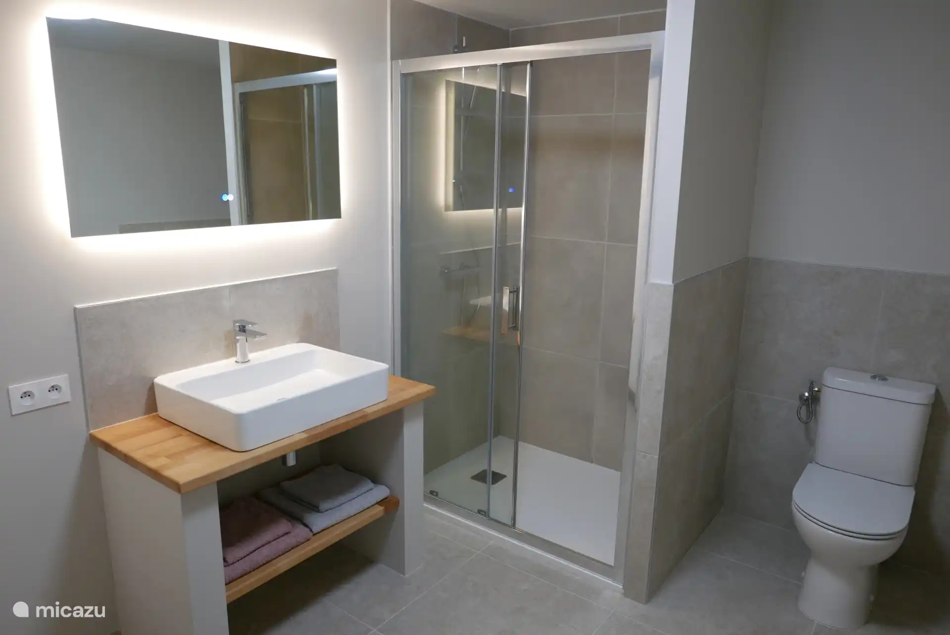 Bathroom on the ground floor with shower, a dressing table with plenty of space, towel rail, hair dryer, washing machine and dryer. 