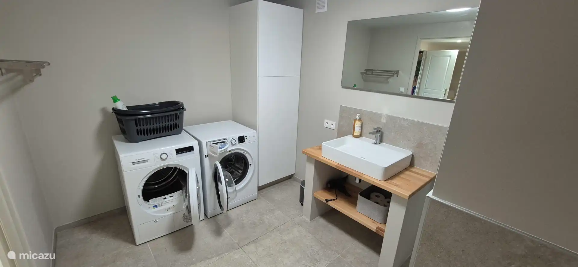 Bathroom on the ground floor with shower, a dressing table with plenty of space, towel rail, hair dryer, washing machine and dryer. 