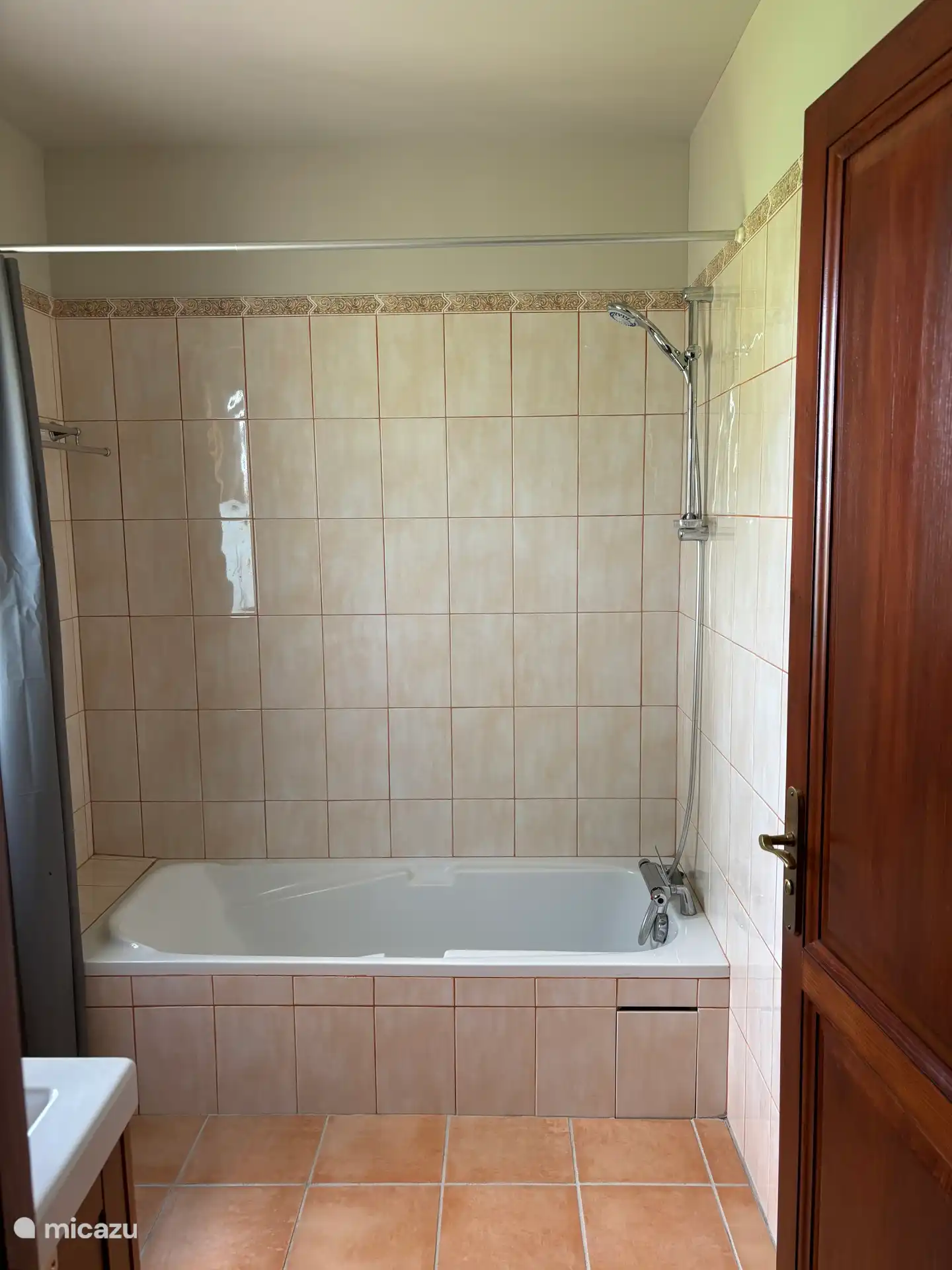 Bathroom with bath and shower, plus a separate adjoining toilet. 