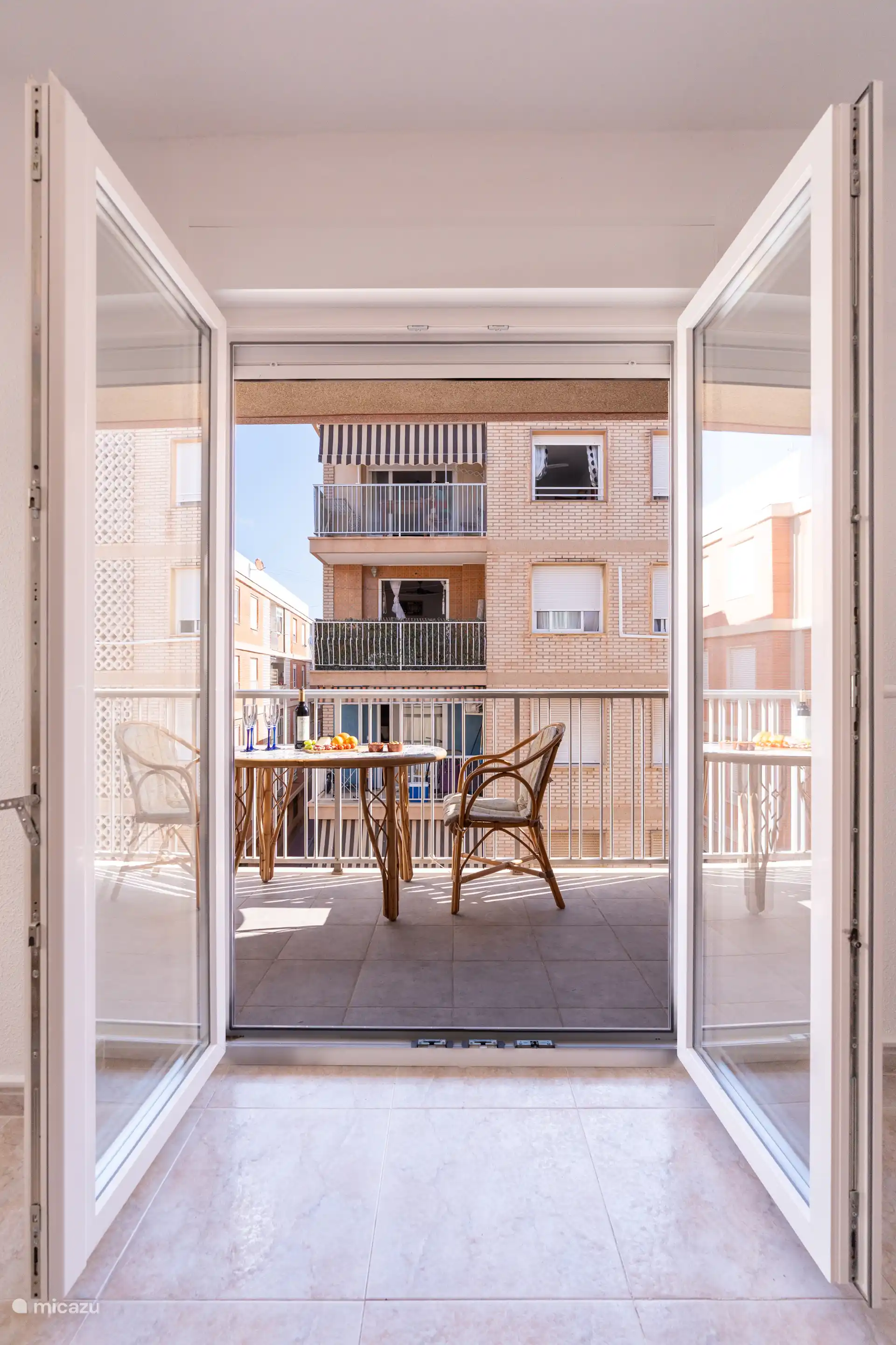À travers les portes-fenêtre, le salon s’enchaîne parfaitement dans le balcon, de sorte que l’intérieur et l’extérieur sont bien connectés.