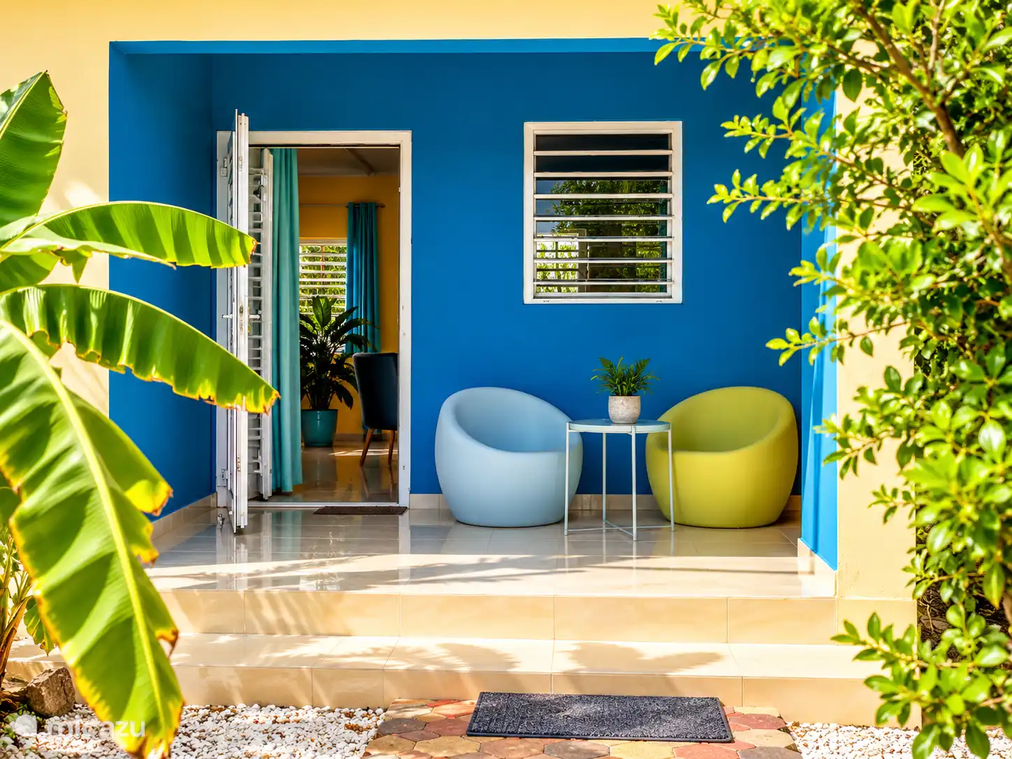 Veranda met zitje aan de voorzijde van Villa Yellow Banana.