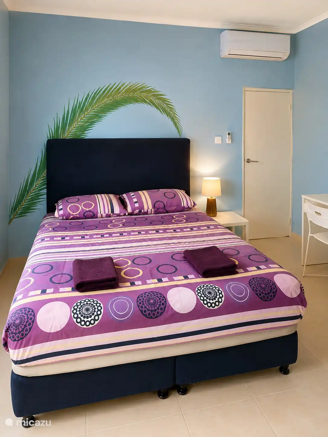 Slaapkamer met en suite badkamer, airconditioning en opbergruimte voor kleding.