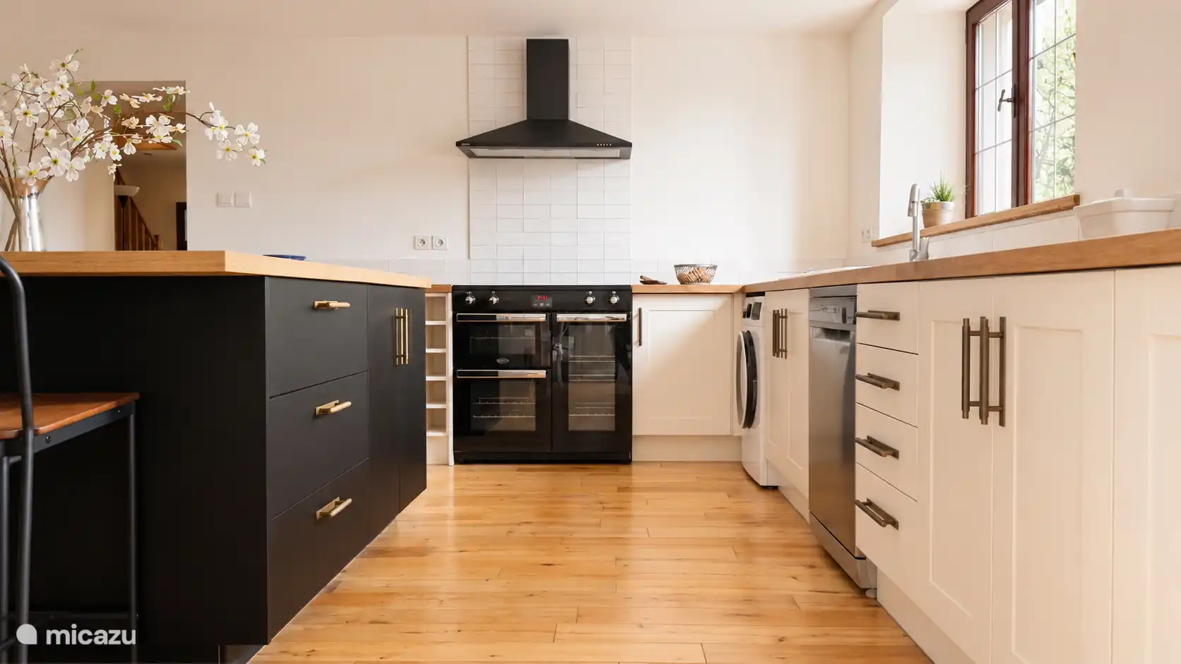 The main Kitchen in Almond View with range cocker, dishwasher, farmstyle sink, washer and catering equipment for 20 people. Glasses in the bar area. 