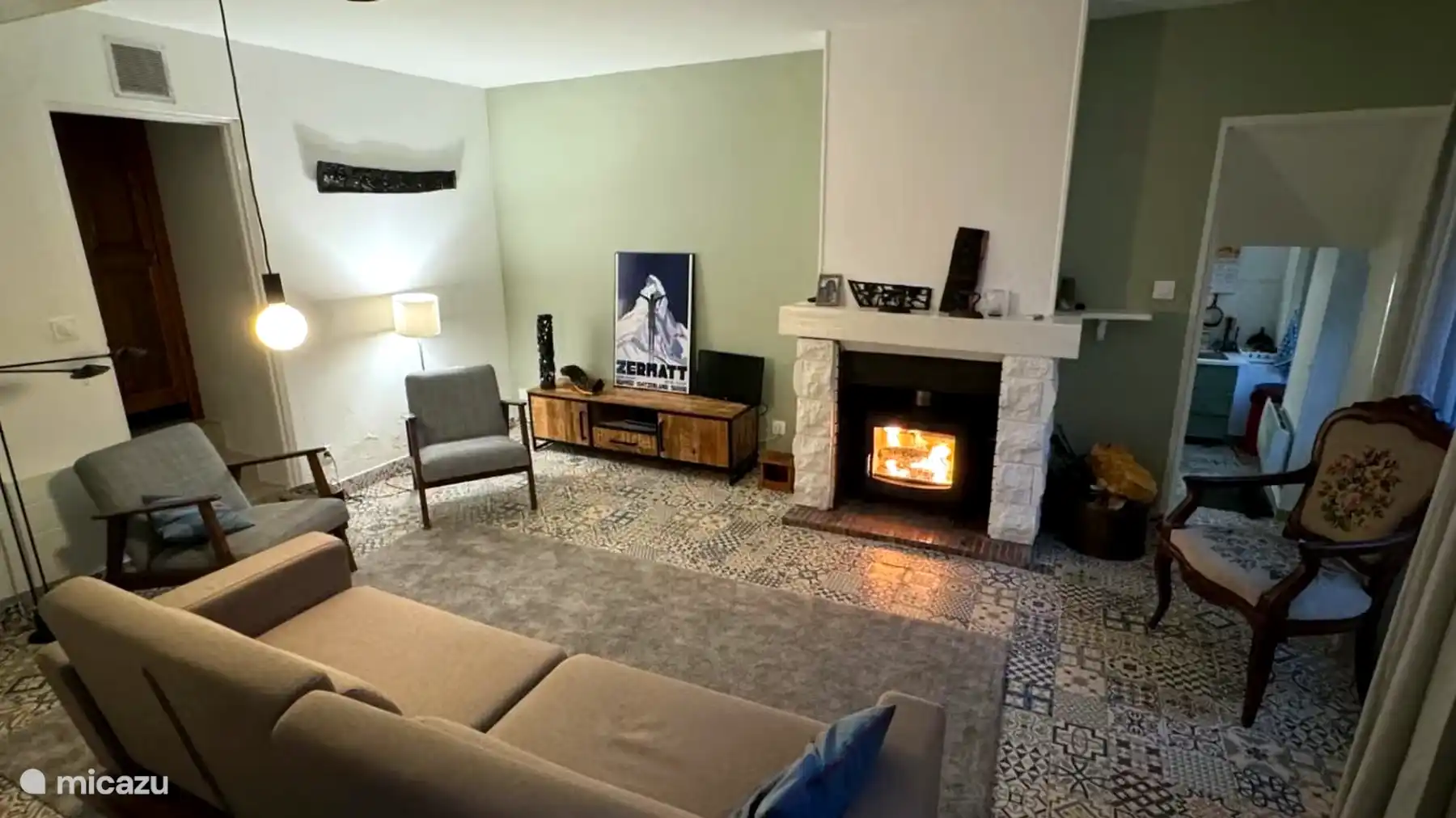 Gezellige woonkamer met houtkachel, tv, PlayStation en grote boekenkast. De comfortabele tweepersoonsslaapbank biedt bovendien extra slaapruimte voor twee gasten.