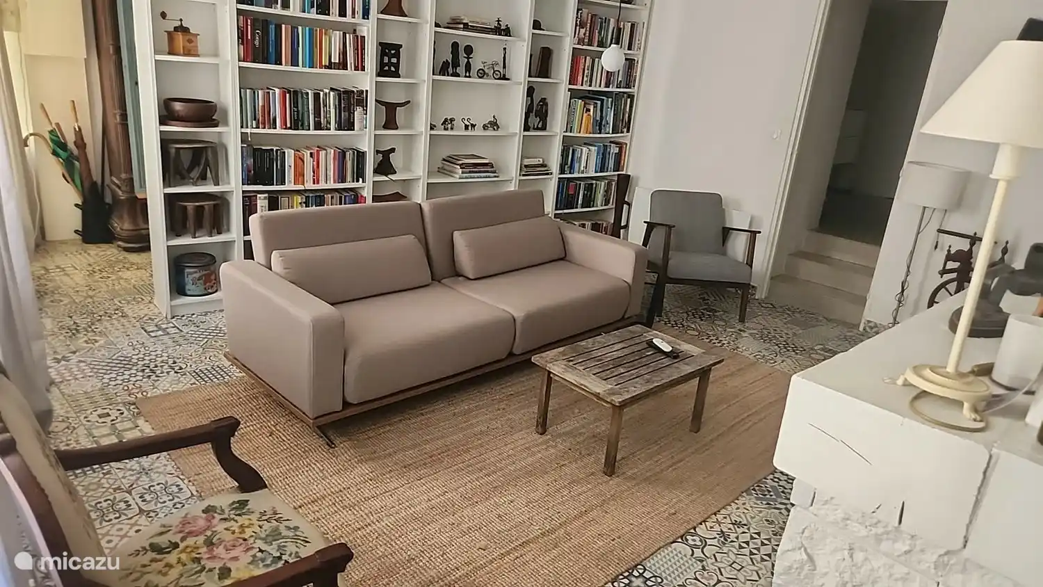 Gezellige woonkamer met houtkachel, tv, PlayStation en grote boekenkast. De comfortabele tweepersoonsslaapbank biedt bovendien extra slaapruimte voor twee gasten.