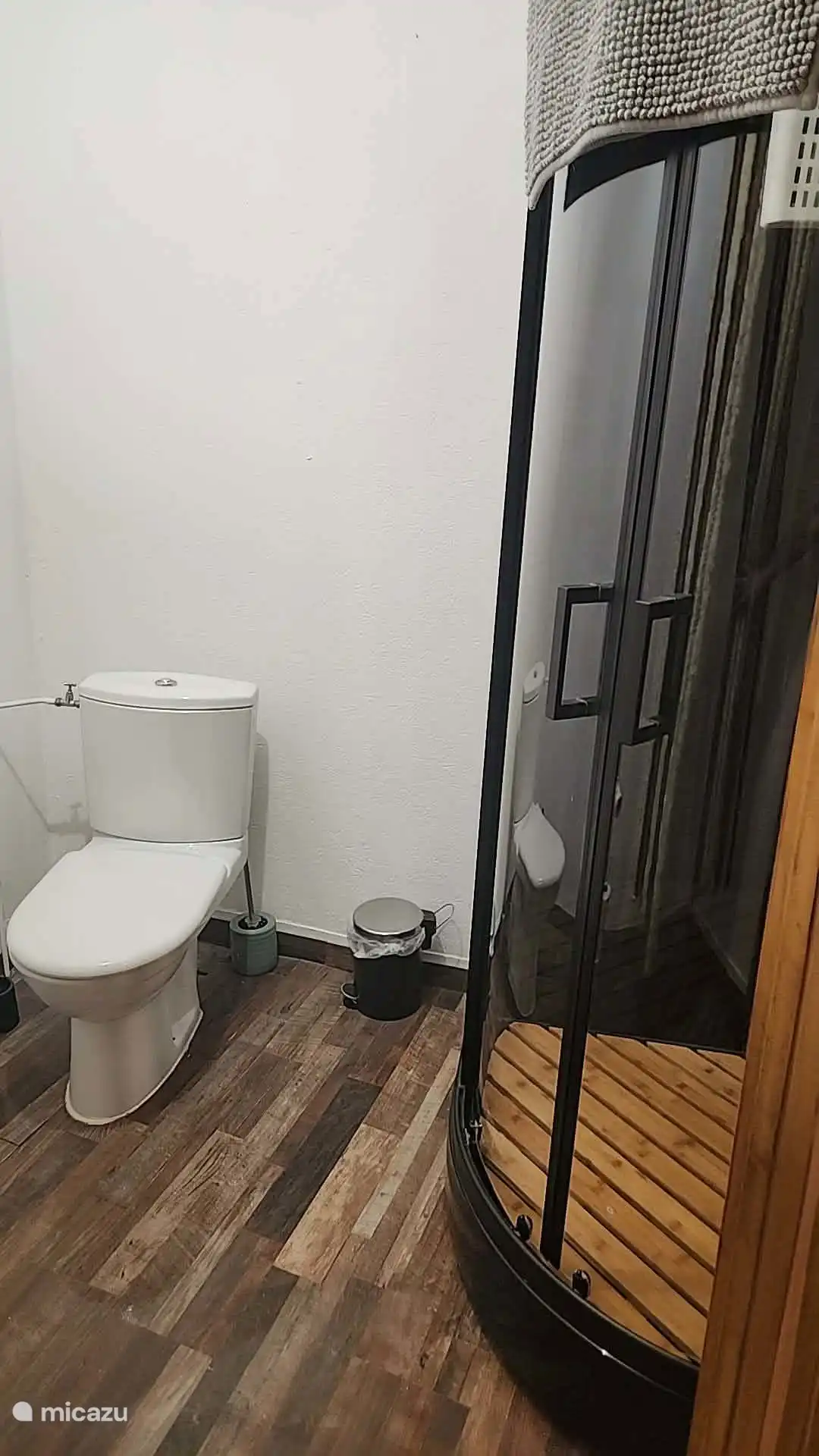 Compacte badkamer in de tweede slaapkamer, voorzien van douche en toilet. Praktisch en comfortabel, met de voorzieningen direct in de kamer.