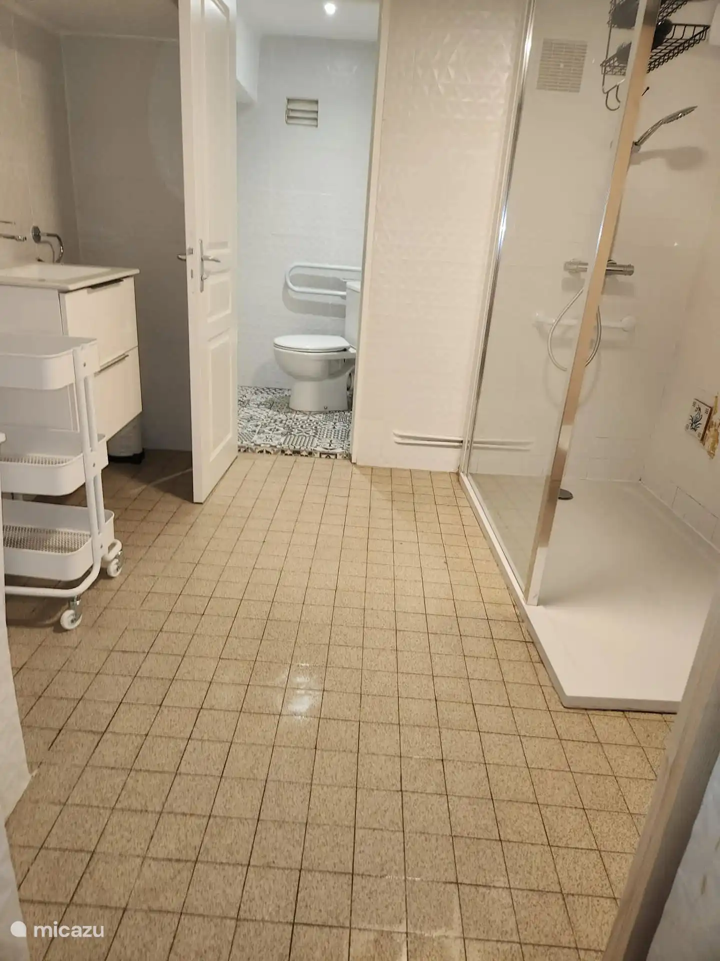 Ruime badkamer op de begane grond met comfortabele douche en wastafel. Het toilet bevindt zich in dezelfde ruimte, maar is afzonderlijk afsluitbaar.