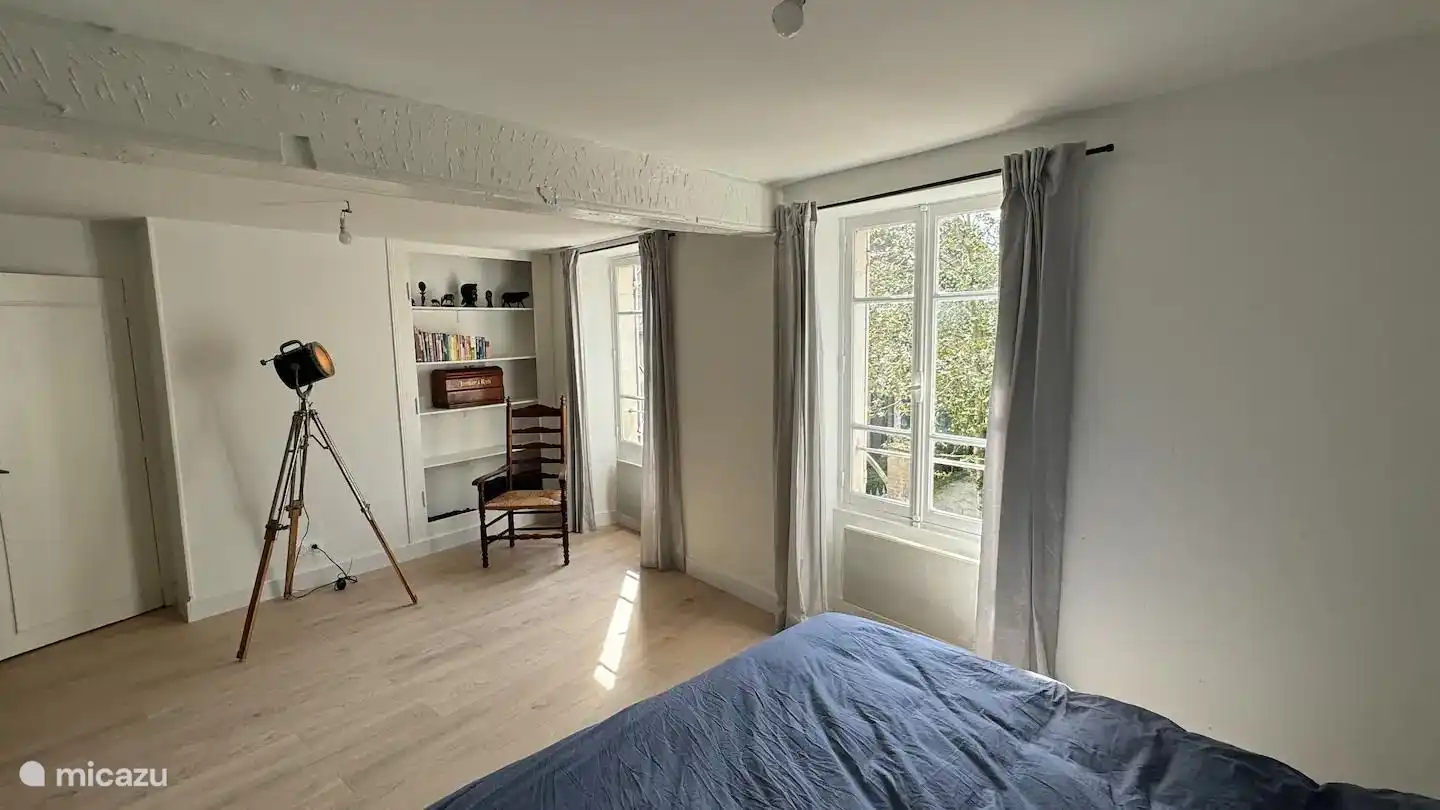 Grote, lichte slaapkamer met comfortabel tweepersoonsbed, bureau met werkplek, kast en kledingrek. Ruim, rustig en prettig ingericht voor een ontspannen verblijf.