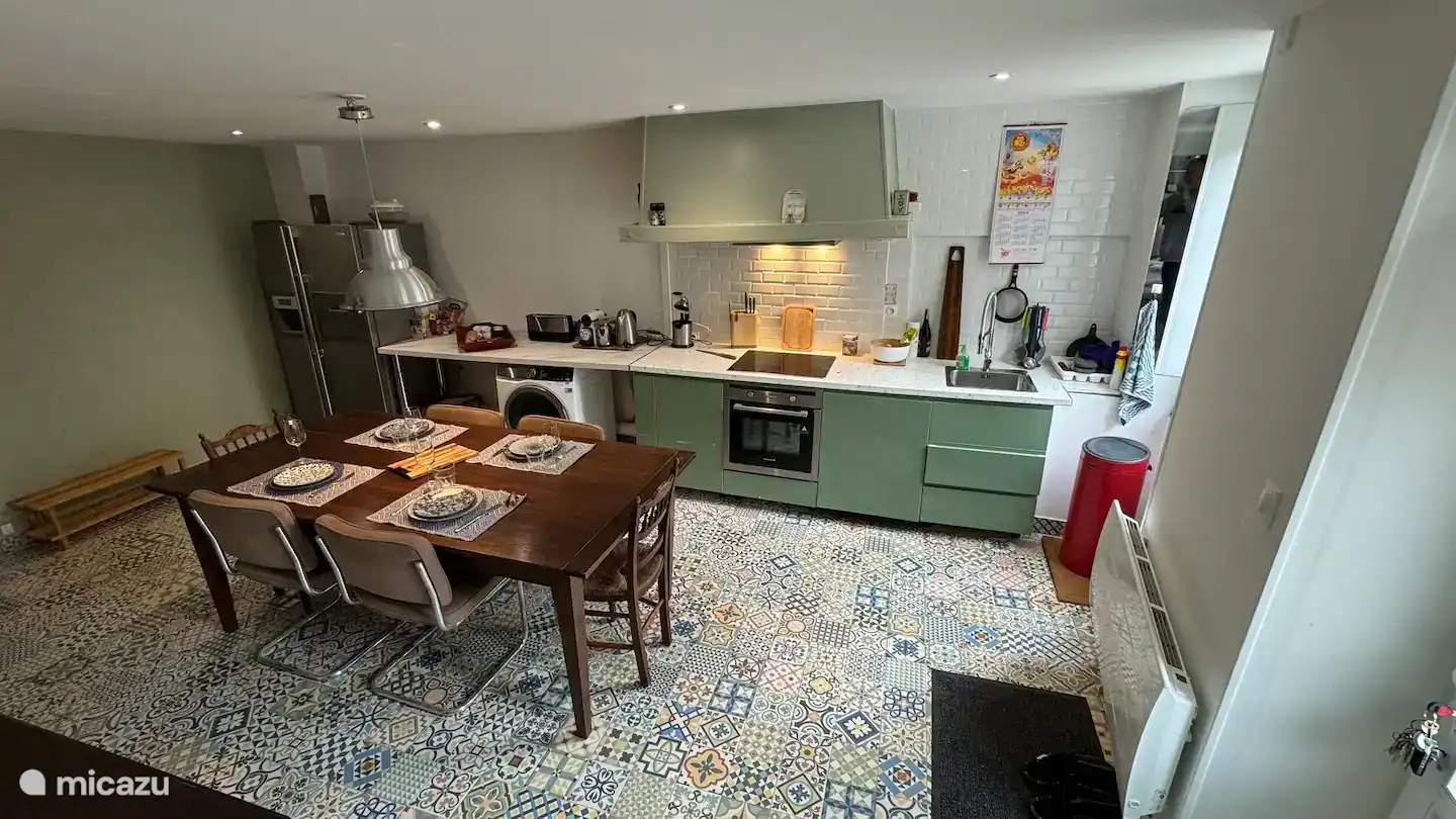Ruime, moderne keuken met Amerikaanse koelkast, wijnkoelkast, wasmachine en droger. Ook een gezellige eetruimte, vanaf najaar 2026 extra sfeervol met houtkachel.