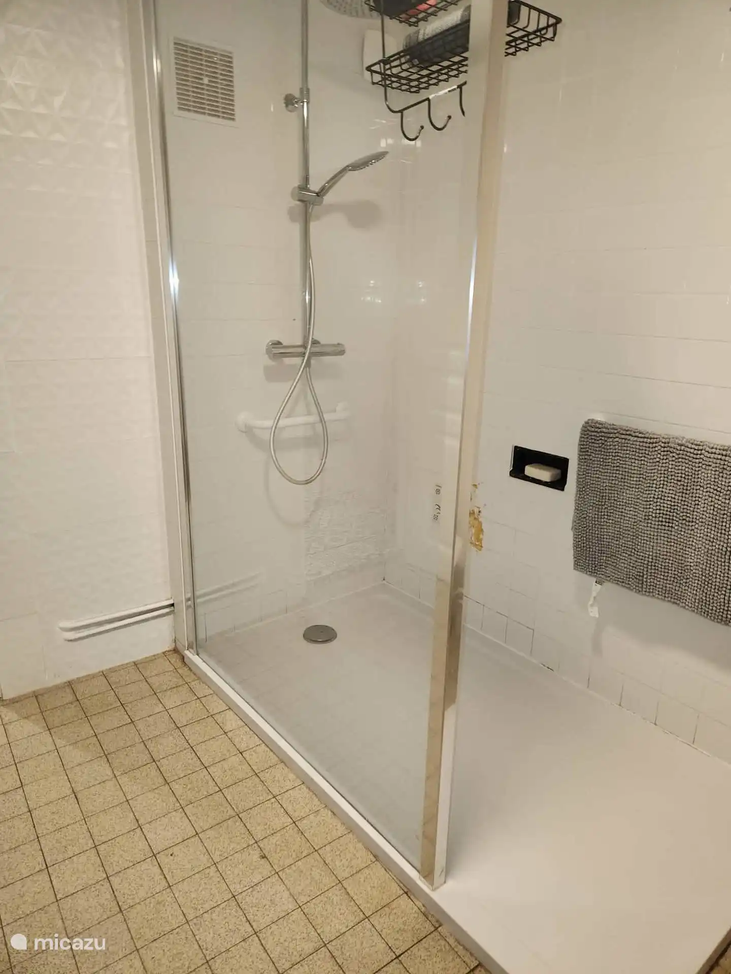 Ruime badkamer op de begane grond met comfortabele douche en wastafel. Het toilet bevindt zich in dezelfde ruimte, maar is afzonderlijk afsluitbaar.