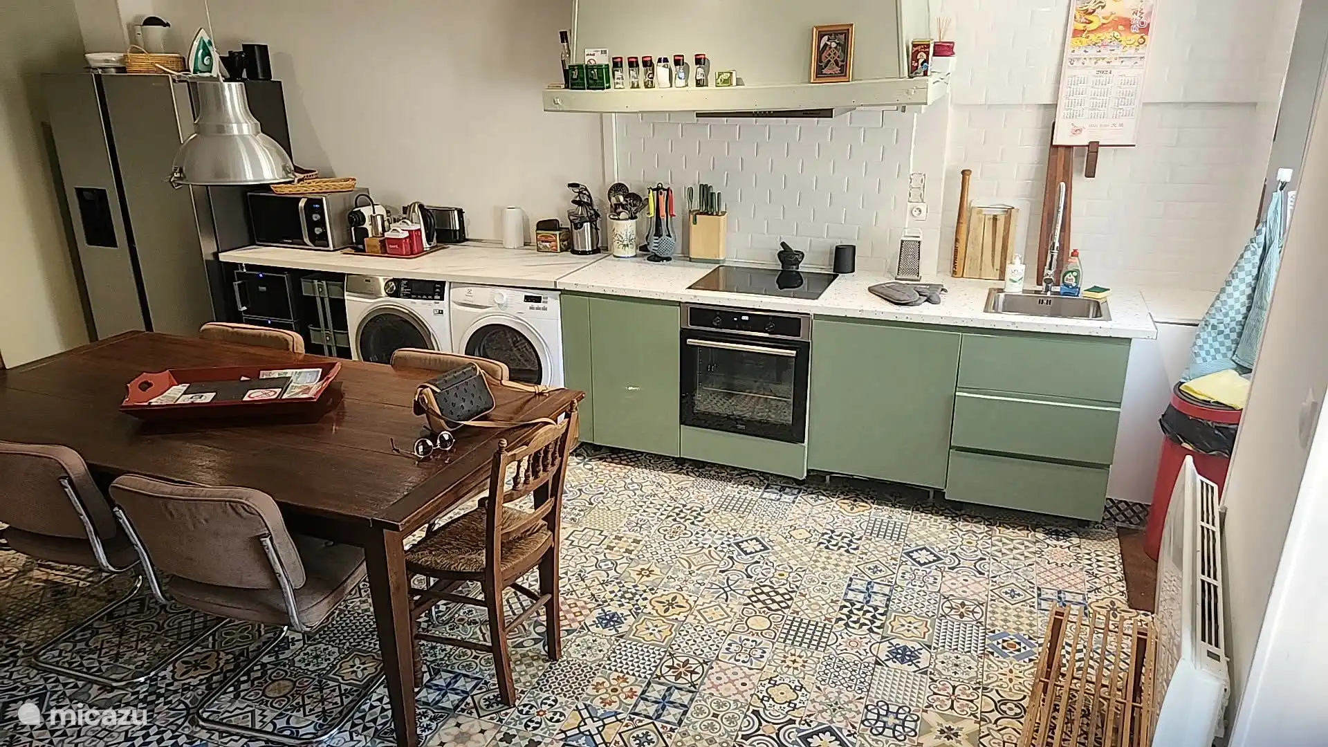 Ruime, moderne keuken met Amerikaanse koelkast, wijnkoelkast, wasmachine en droger. Ook een gezellige eetruimte, vanaf najaar 2026 extra sfeervol met houtkachel.