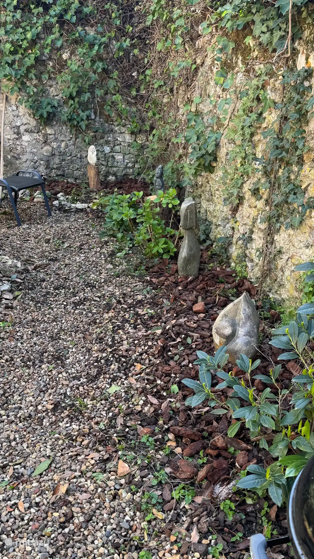 Sfeervolle beeldentuin met diverse Afrikaanse beelden, direct aan de tuinkamer. Een beschutte en bijzondere plek om buiten te eten, iets te drinken of rustig van de sfeer te genieten.