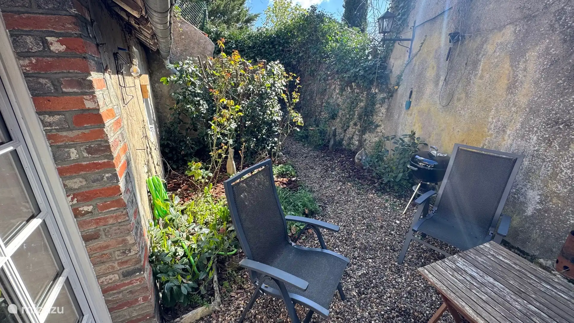 Sfeervolle beeldentuin met diverse Afrikaanse beelden, direct aan de tuinkamer. Een beschutte en bijzondere plek om buiten te eten, iets te drinken of rustig van de sfeer te genieten.
