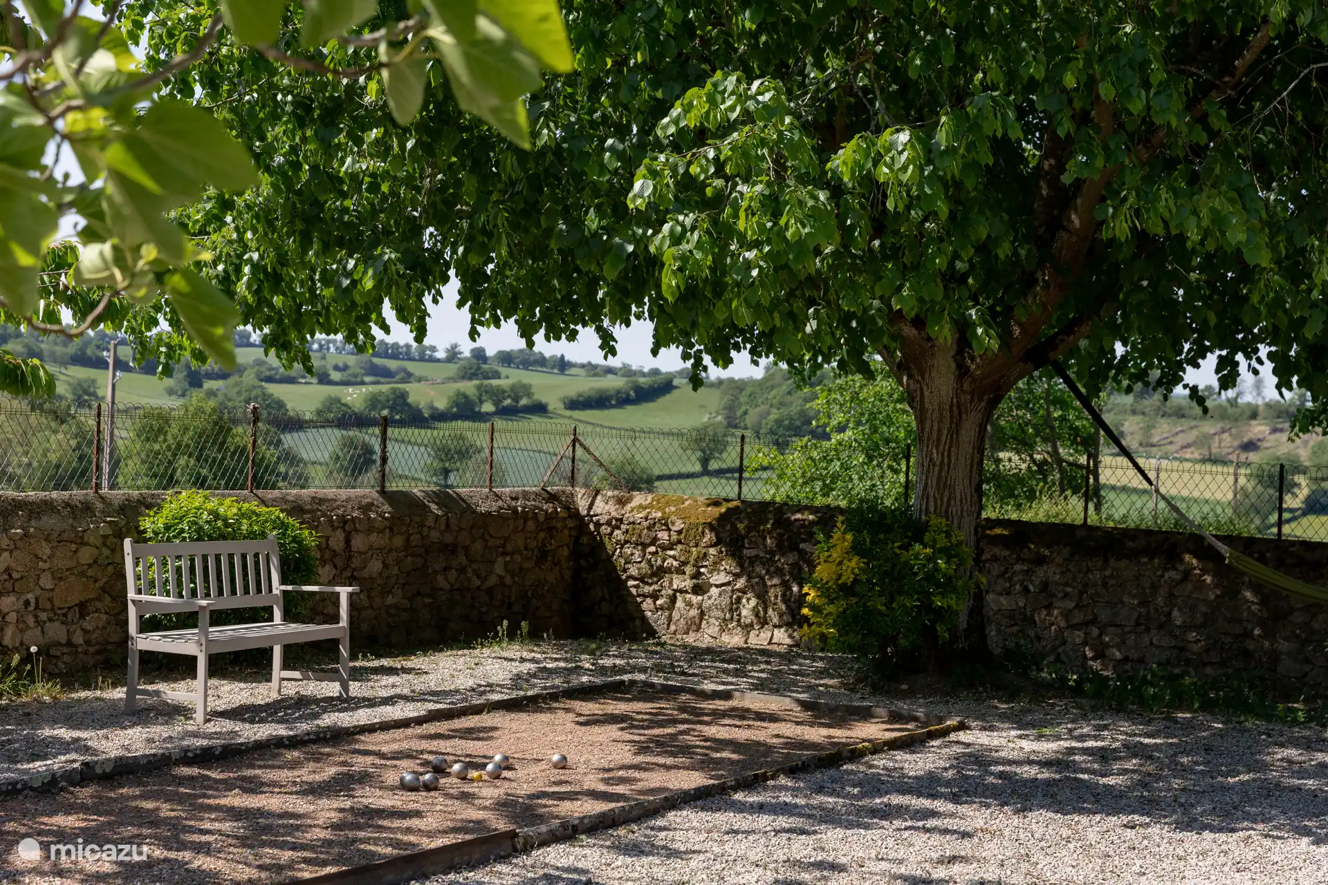 Petanque-Hof mit Aussicht, Hängematte und verschiedenen Sitzbereichen.