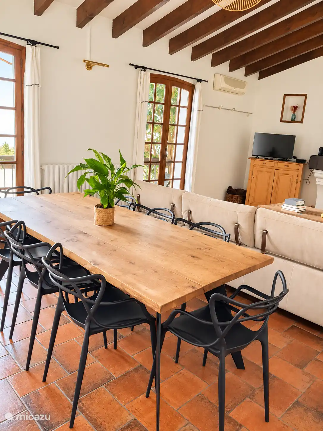 Comedor con 8 asientos en la mesa, abierto al salón y con terraza