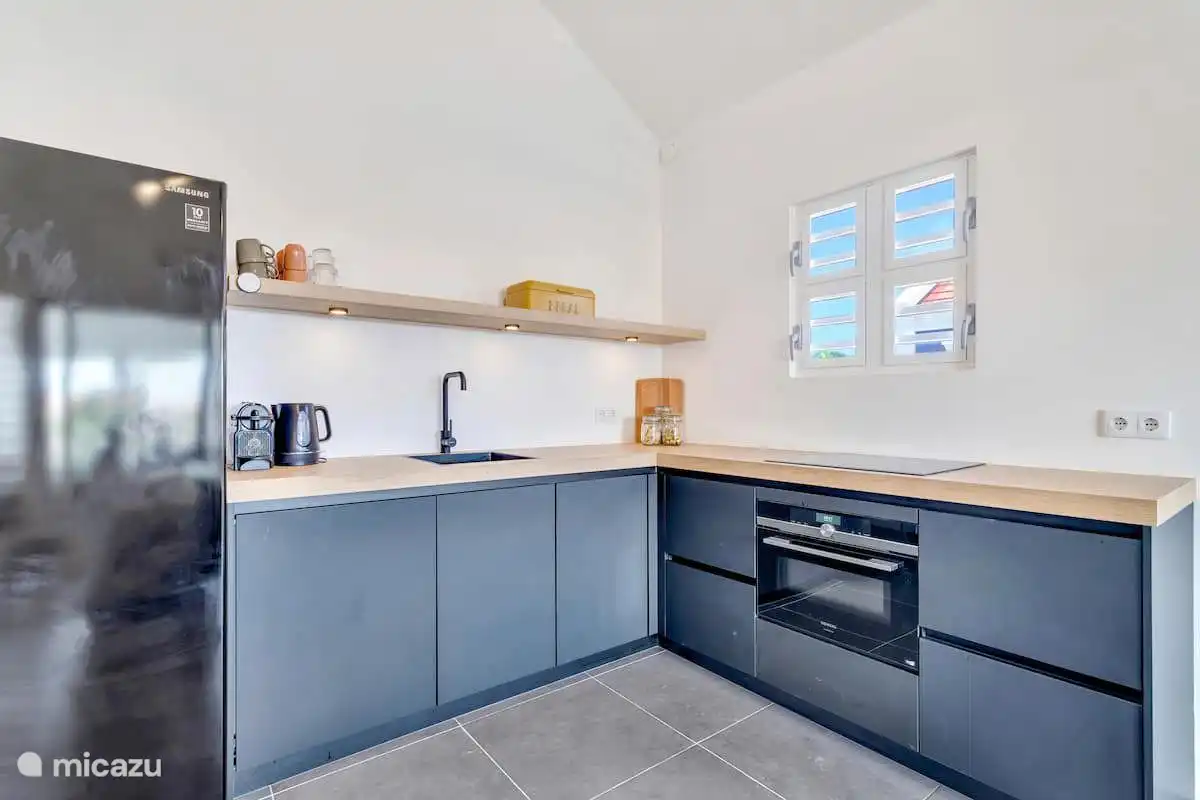 Küche mit Arbeitsplatte, Spüle und Kühlschrank.