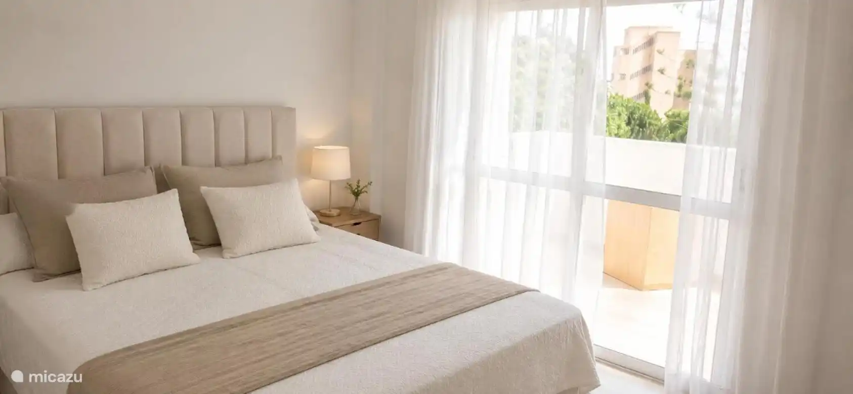 Chambre principale avec lit double et accès au balcon