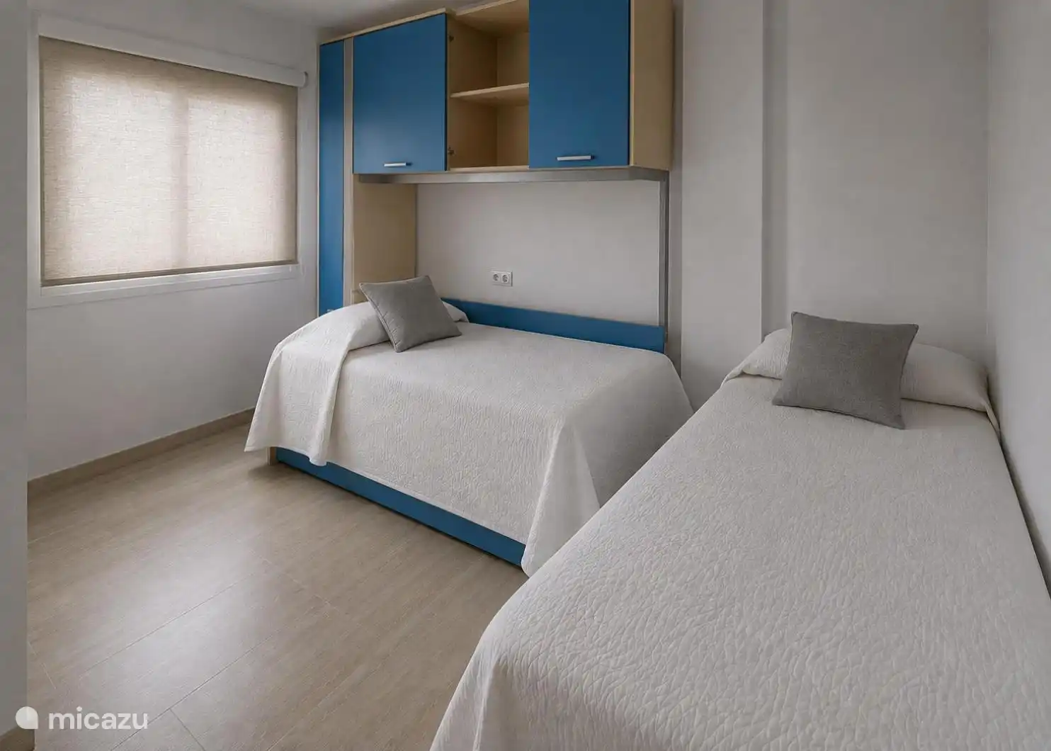 Chambre avec deux lits simples et armoires encastrées