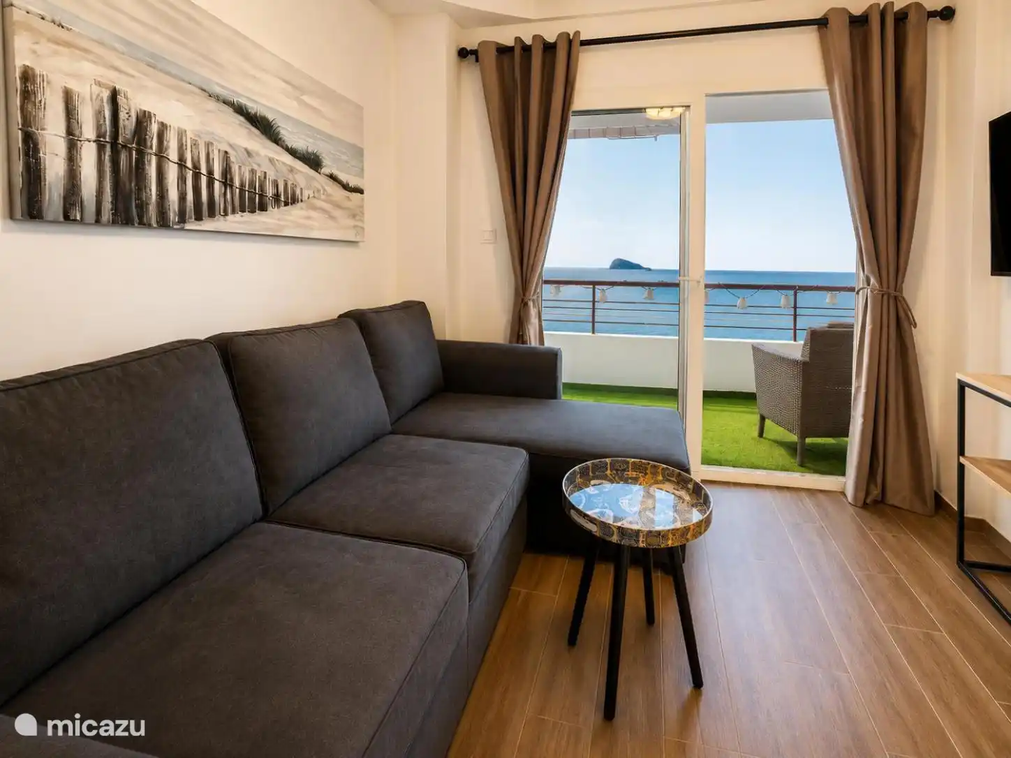 Salon avec canapé et accès au balcon avec vue sur la mer