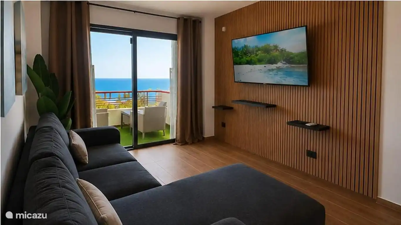 Living room with double sofa bed, smart TV and access to the terrace with sea views