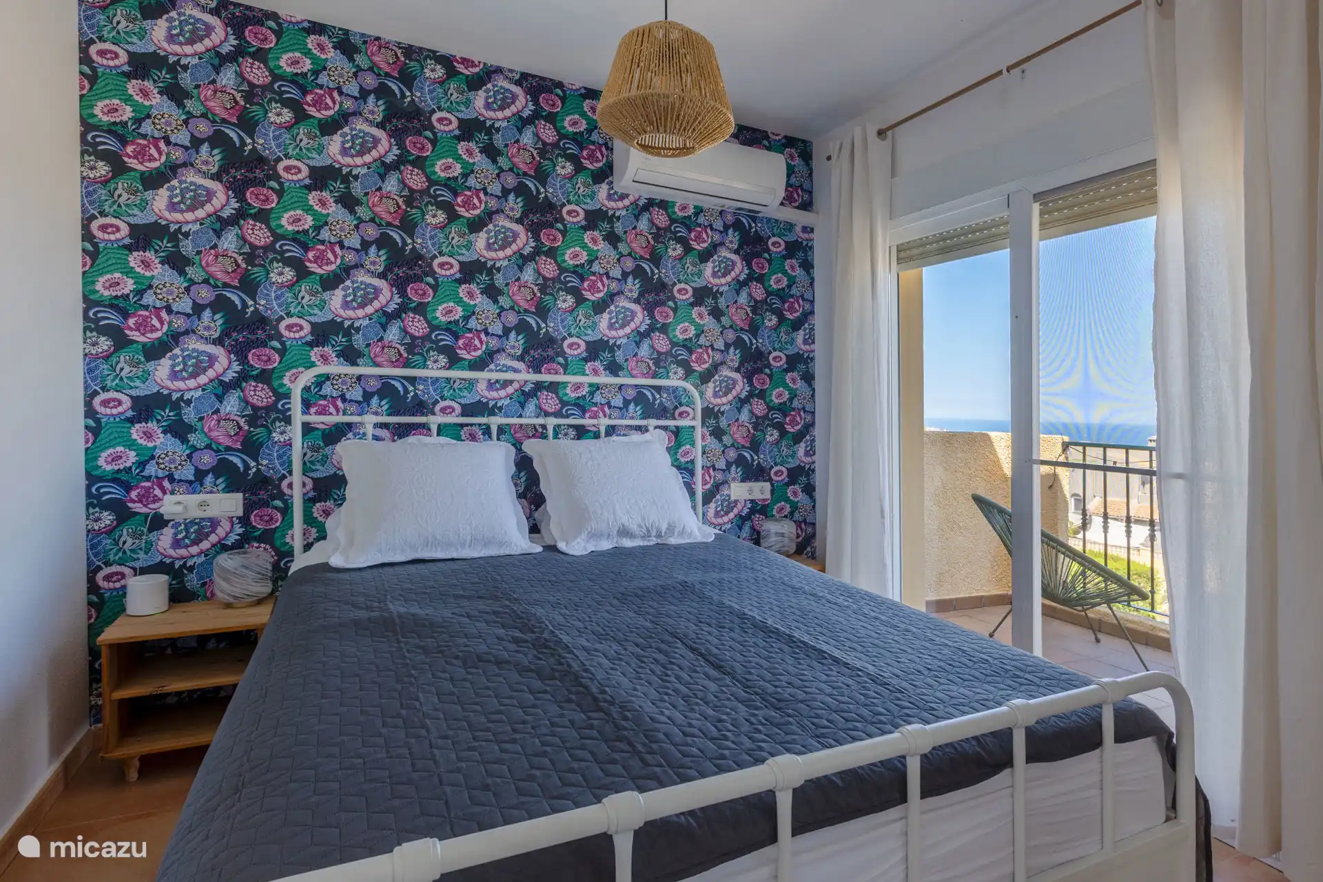Slaapkamer met tweepersoonsbed en balkon met prachtig uitzicht op de eerste etage