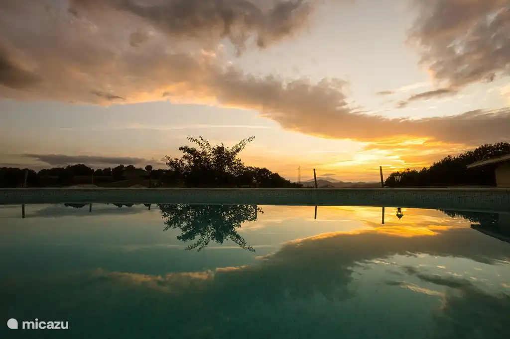 zwembad met ondergaande zon