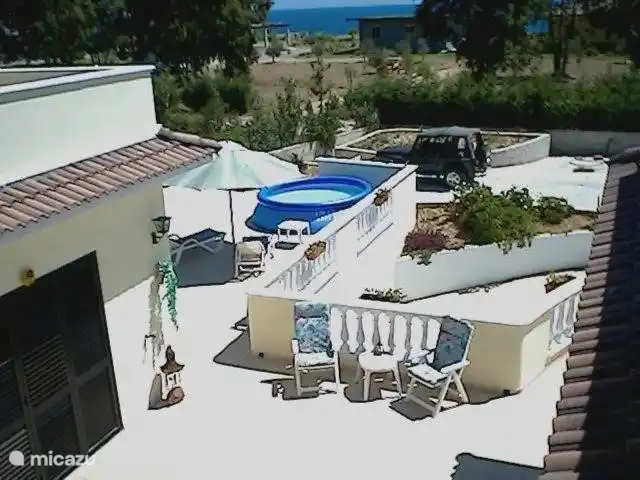 Übersicht untere Terrasse mit Kinderbecken und Liegestühlen.