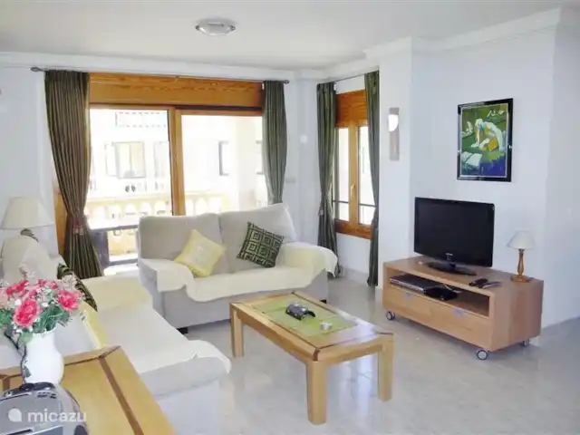 Playa Moncayo en España, Costa Blanca, Guardamar del Segura - apartamento nuestro salón con sofá de dos y tres plazas, zona de comedor con mesa y seis sillas, TV, aire acondicionado y acceso a la terraza de 12m².