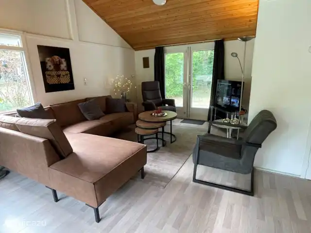 Vakantiewoning Oase huren in Nederland, Drenthe, Exloo - bungalow De gezellige en comfortabele woonkamer heeft een goed zittend bankstel, een relaxfauteuil en aan twee zijden openslaande tuindeuren en een grote televisie