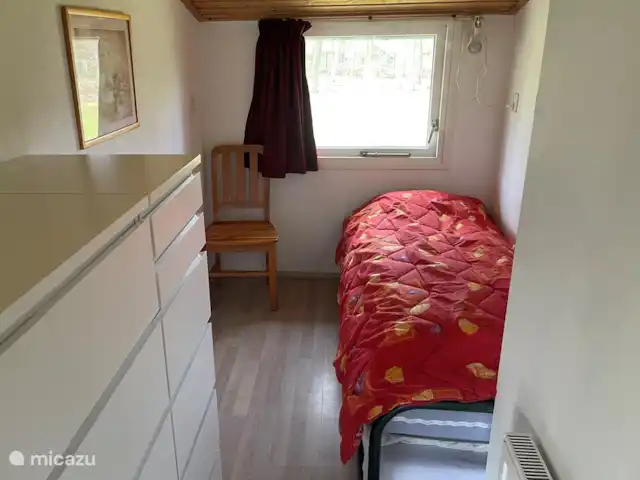 Vakantiewoning Oase huren in Nederland, Drenthe, Exloo - bungalow In deze kleine slaapkamer staat een bed met onderschuifbed (80 cm breed). In de ladenkast op de voorgrond is er ruimte om kleding op te bergen. Ook ligt er wat kinderspeelgoed en spelllen.