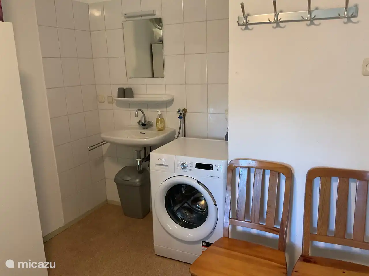 De wastafel en een wasmachine op de grote slaapkamer