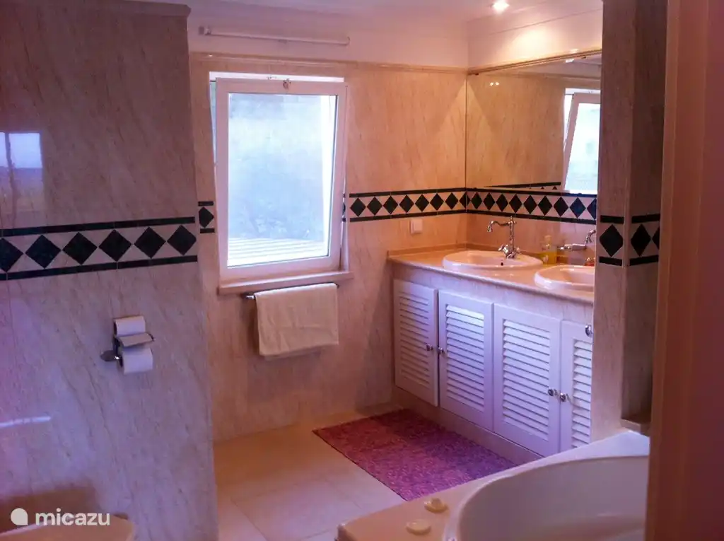 Salle de bain principale avec jacuzzi et douche à effet pluie