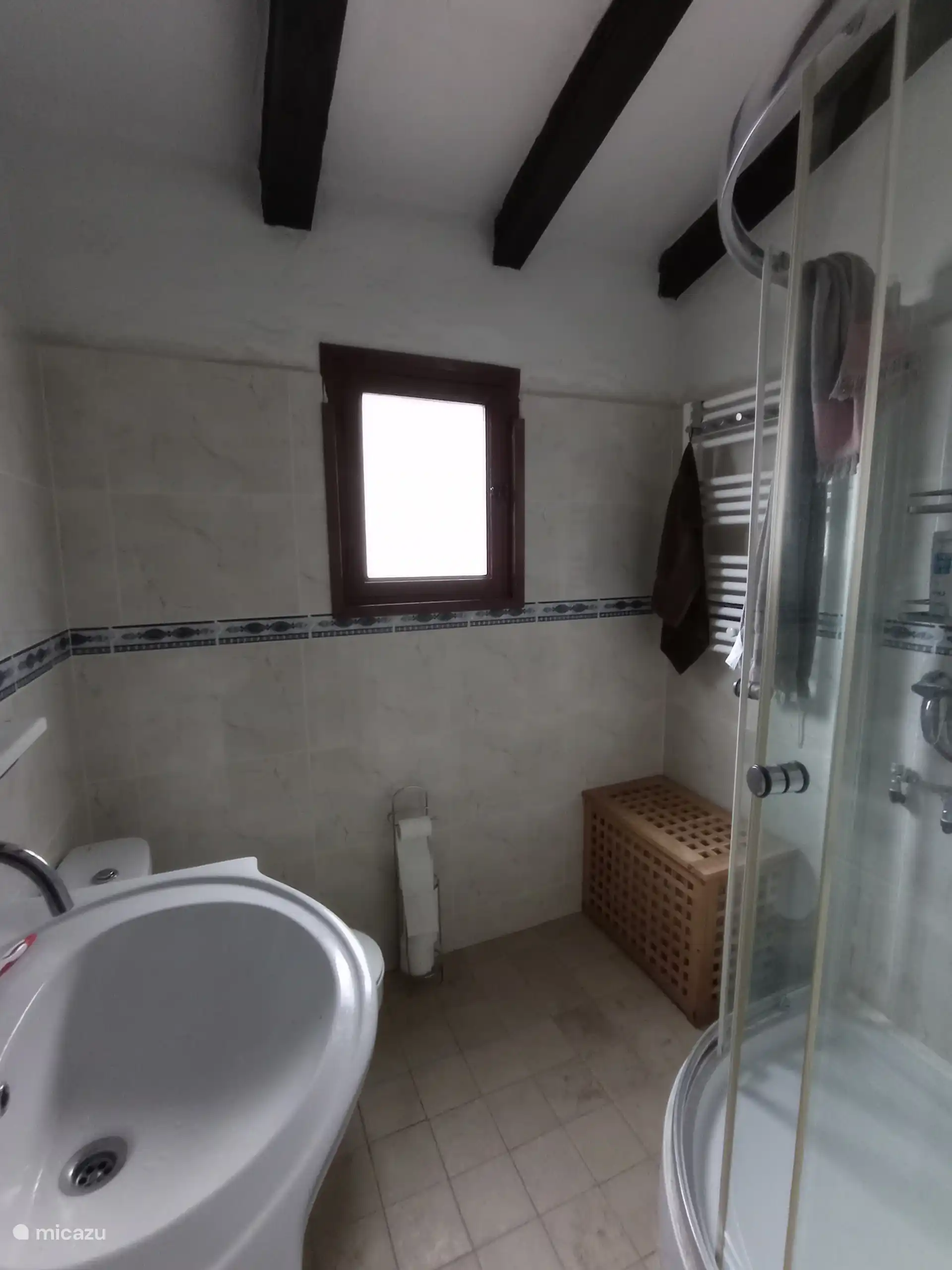 badkamer met wasmand.  wasmachine in het washuisje buiten.