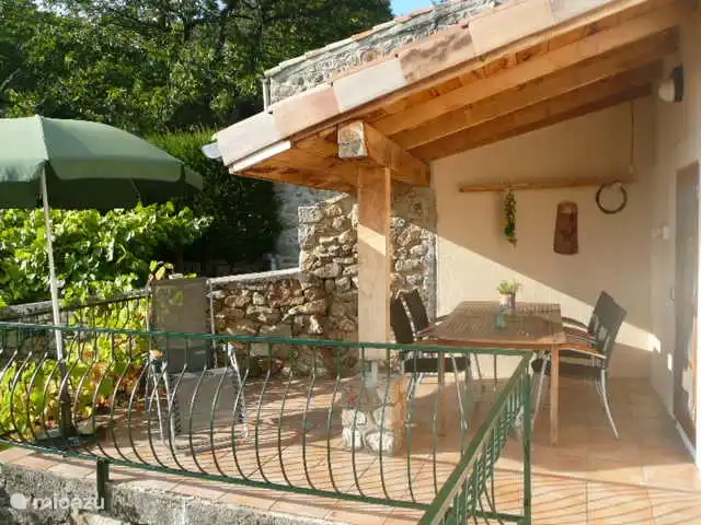 Belle terrasse ensoleillée couverte avec mobilier de jardin neuf