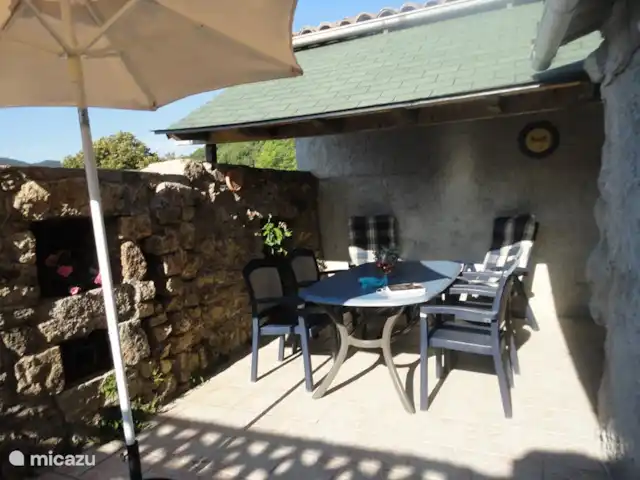 Wandelen, Frankrijk, Ardèche, Gluiras, vakantiehuis La basse Maza - La Glycine Andere zijde van het betelgelde achterterras met overkapping,  en diningset met 6 stoelen en el. kogelbbq.