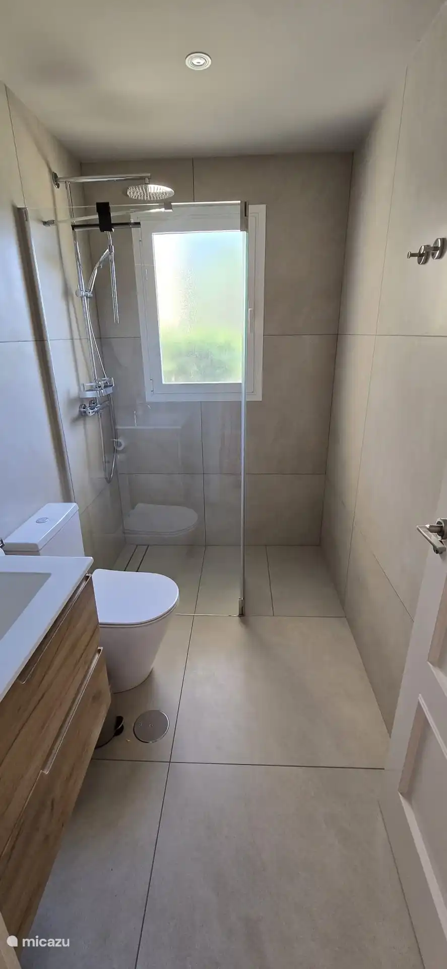 Volledig vernieuwde badkamer met badmeubel, douche en toilet bij de azuur slaapkamer