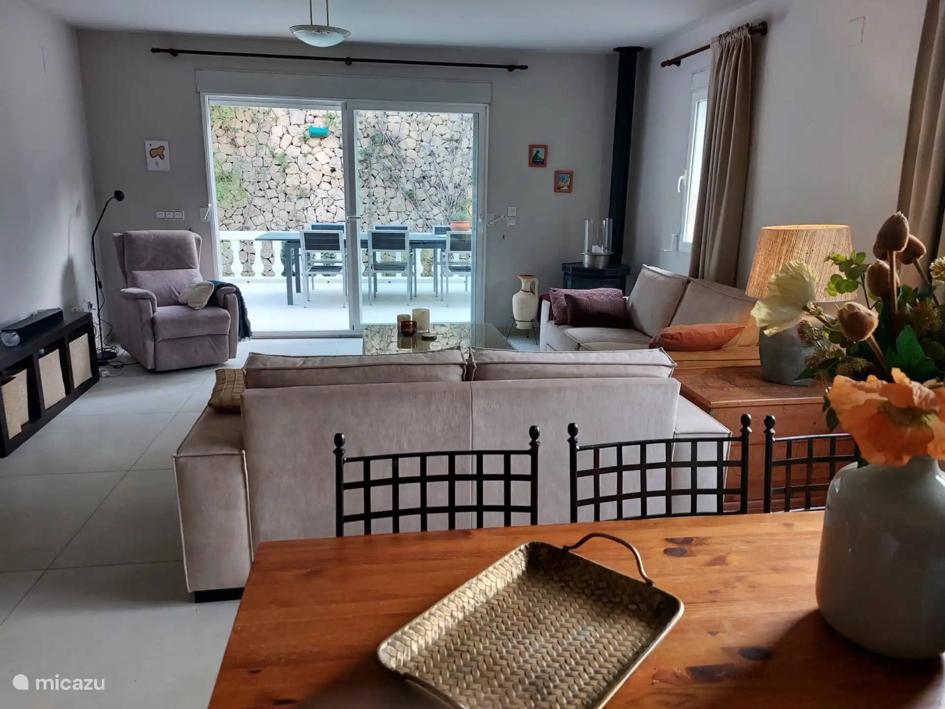 De woonkamer met nieuwe vloer, schilderwerk en op de achtergrond een doorkijkje naar één van de terrassen voor gezellige eetmomenten.