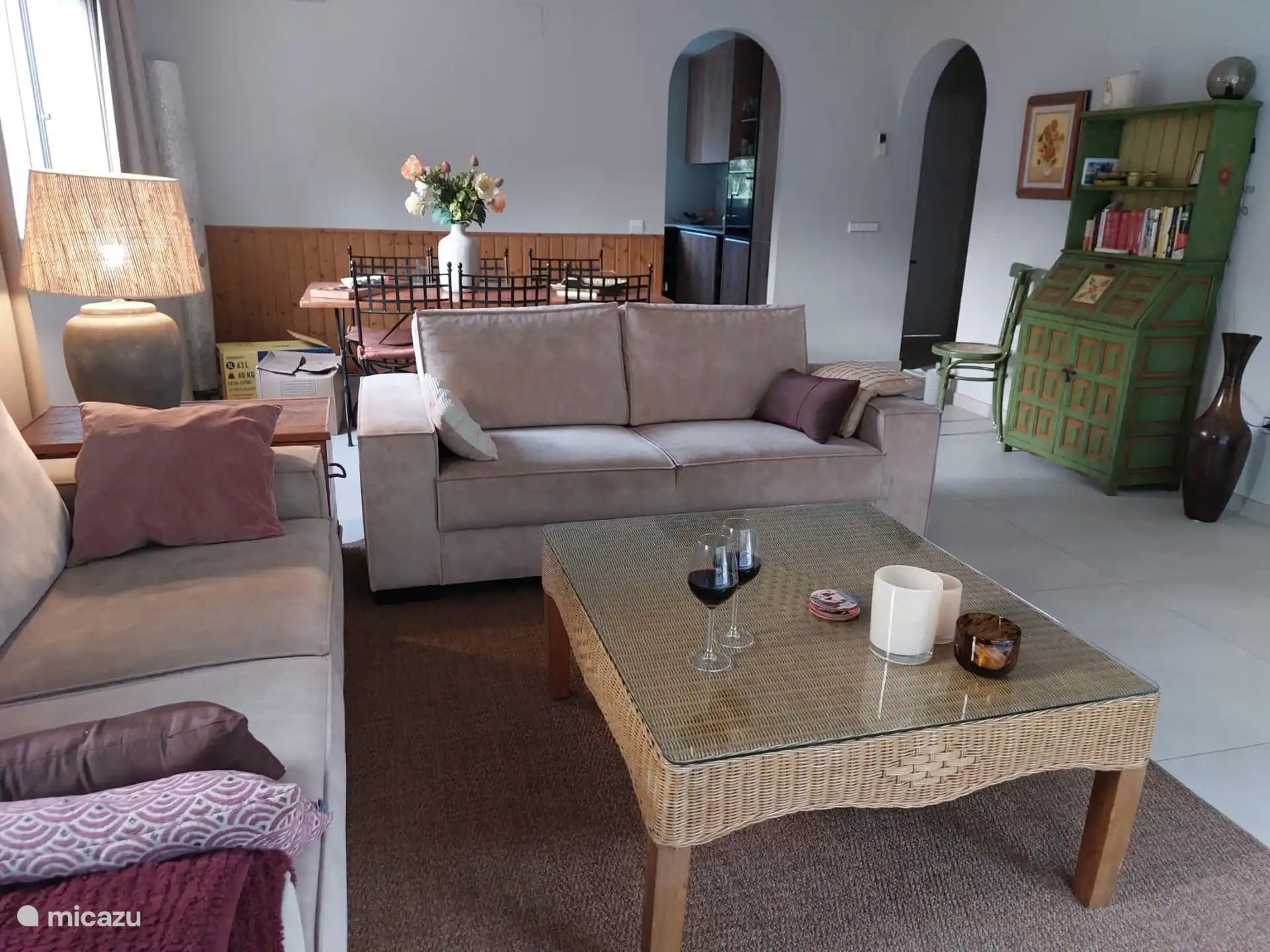 Foto van zithoek en eethoek met 6 stoelen en doorkijkje naar de hoekkeuken. 