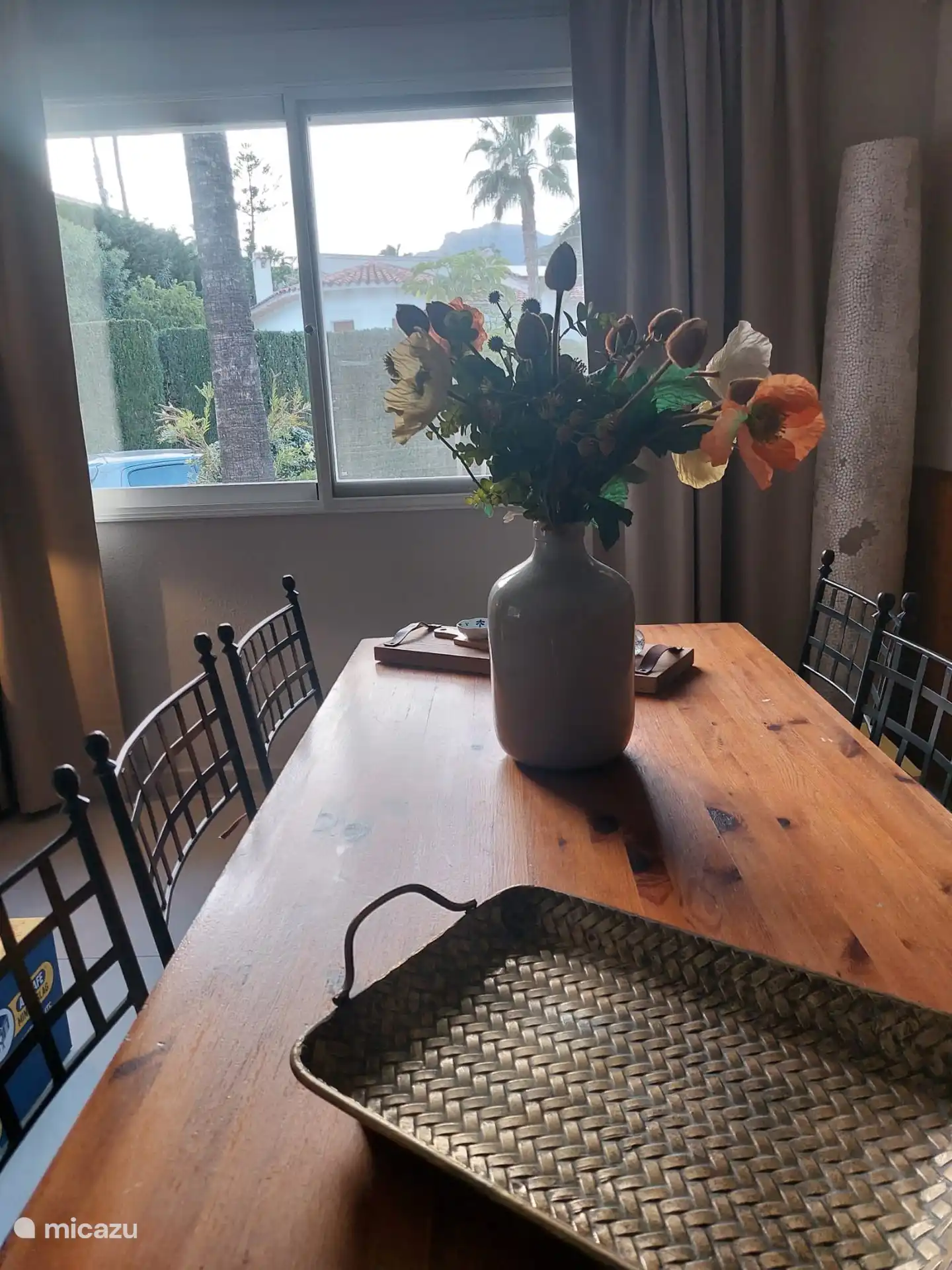 Eettafel binnen met uitzicht op de palmbomen en de bergen van de Sierra de Aitana en Sierra de Bernia.