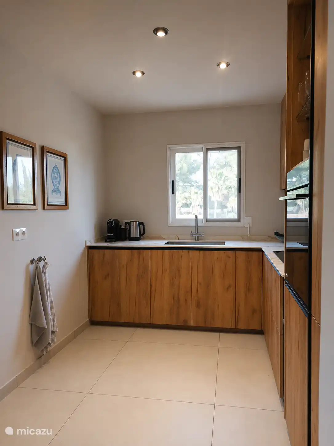 Innenraum mit neuer Küche und Boden, mit Bosch-Geschirrspüler, Wasserhahn mit Filter für Trinkwasser, Nespresso-Maschine mit Milchaufschäumer und Wasserkocher. 