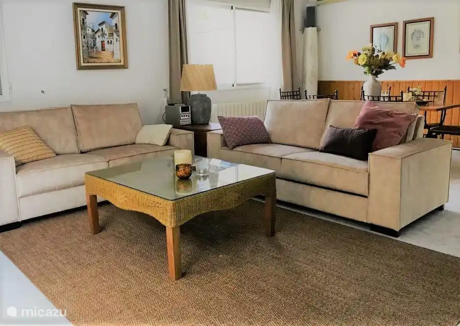 Salon avec de nouveaux canapés, des coussins décoratifs douillets, des plaids et un bel éclairage d'ambiance