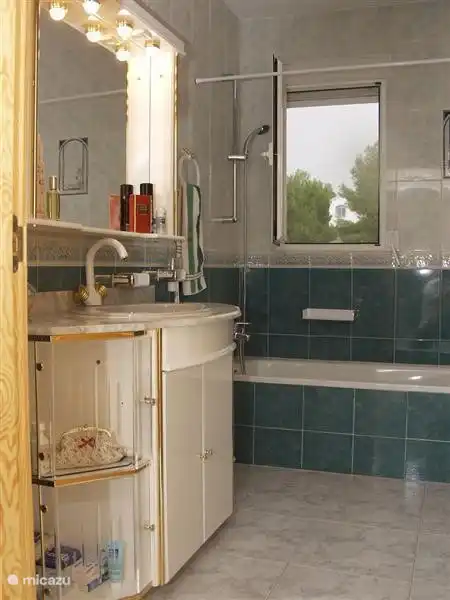 Salle de bain dans la chambre verte, avec baignoire, douchette, WC et chauffage central électrique