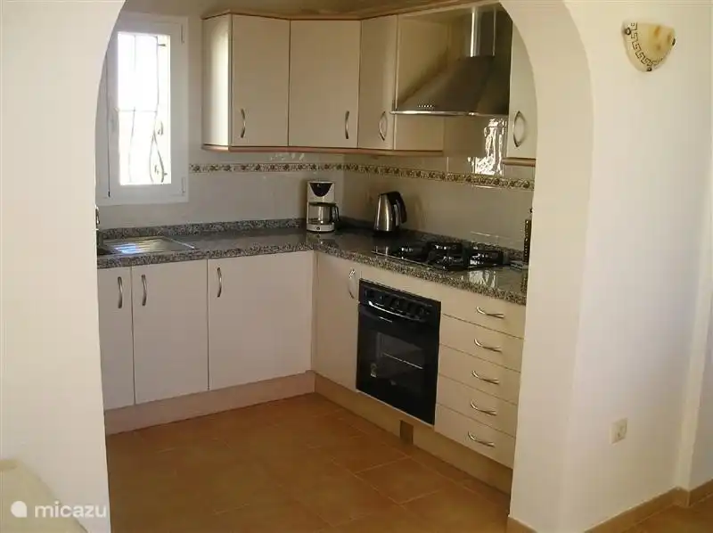 The fully equipped kitchen with oven, stove, fridge, microwave, dishwasher.